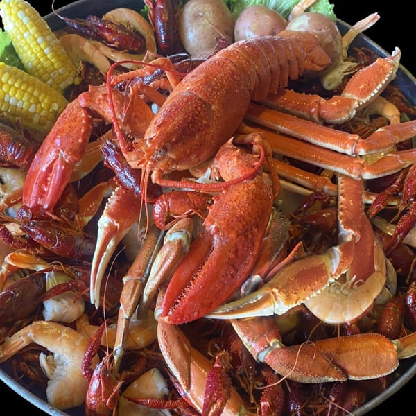 A large Cajun seafood boil with lobster, crab legs, crawfish, shrimp, corn, and potatoes.