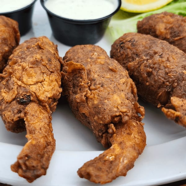Close-up of Crazy Alan's Swamp Shack's fried alligator tails with dipping sauce and lemon.