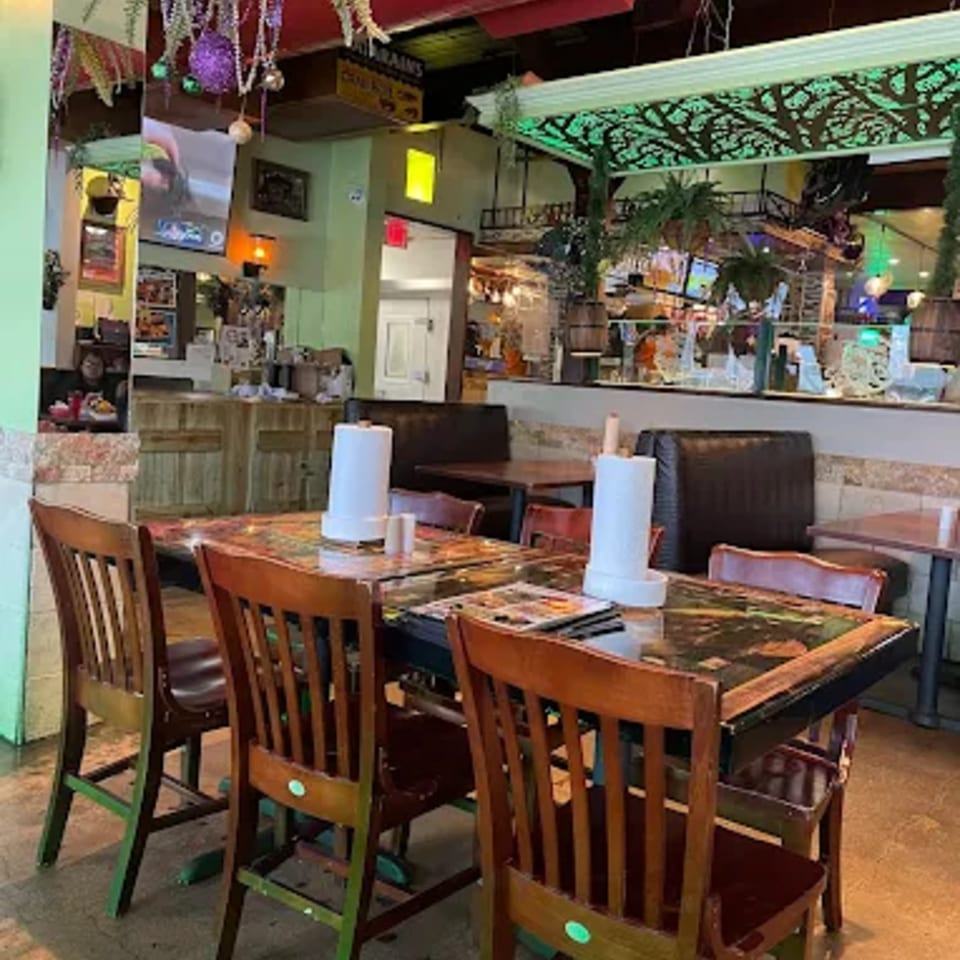 Interior of Crazy Alan's Swamp Shack, showing dining tables with paper towel rolls and Cajun-themed decor.