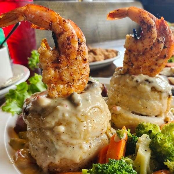 Cajun shrimp and grits with creamy sauce and steamed broccoli and carrots.